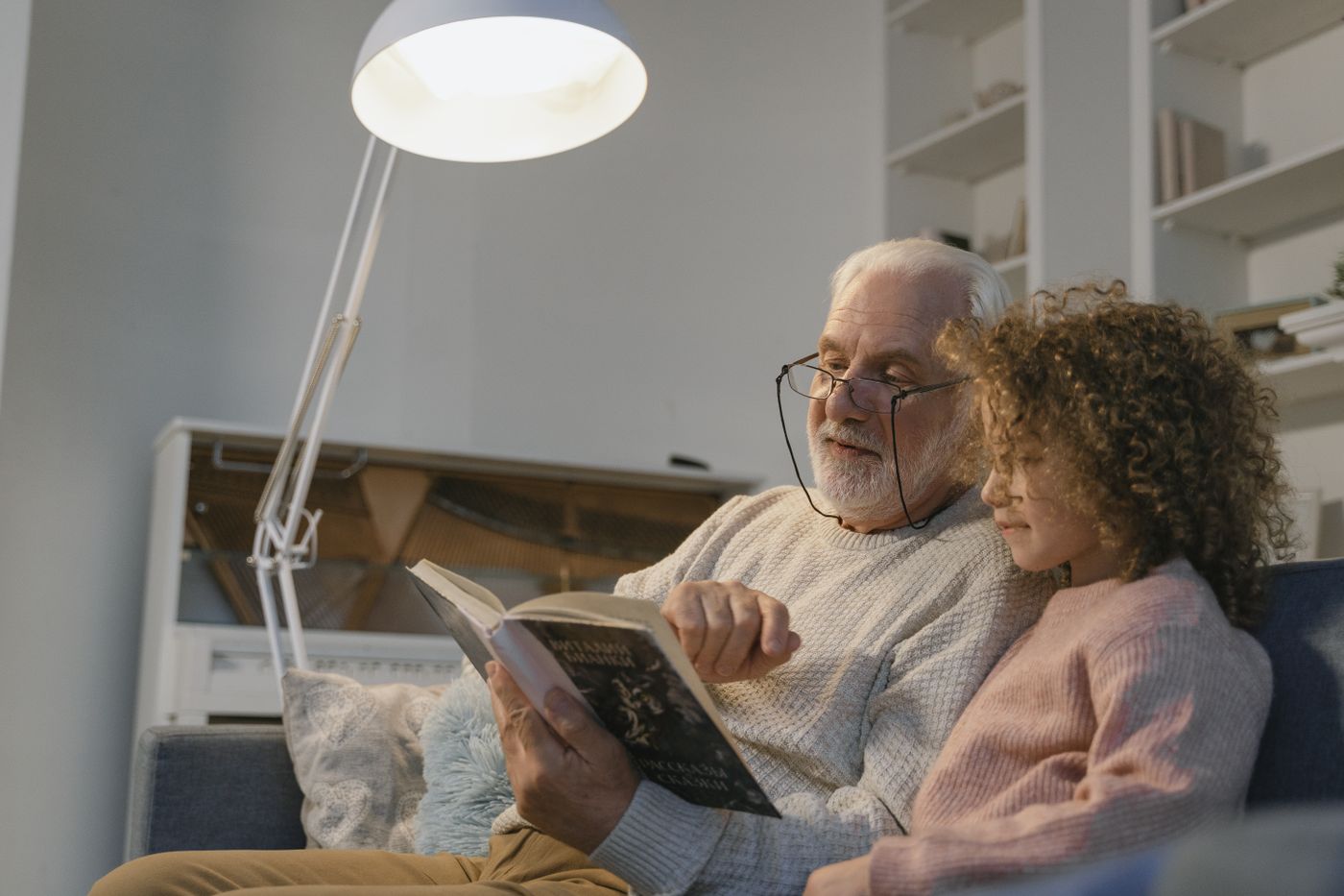 An older adult sharing a book with a child
